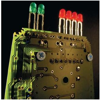 Circuit board with red and green light-emitting diode (LED) indicator lights from a radar detector. (Reproduced by permission of The Stock Market.)